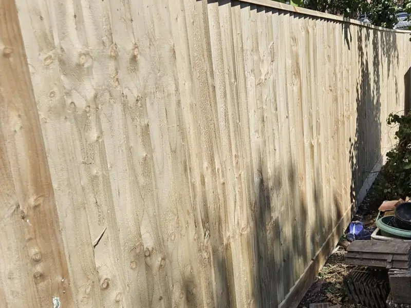 Long run of new closeboard fencing on gravel boards in a back garden