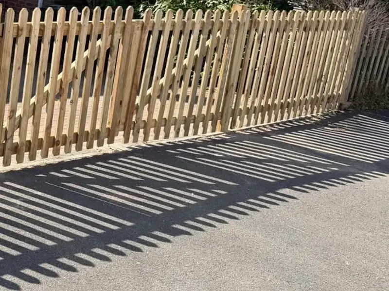 New pointed timber picket fence along a front garden