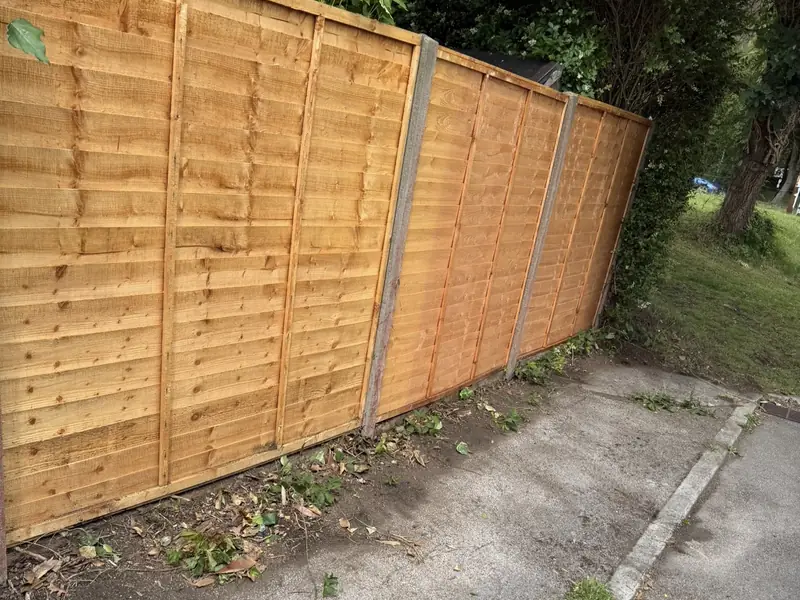 New lap fence panels between concrete posts
