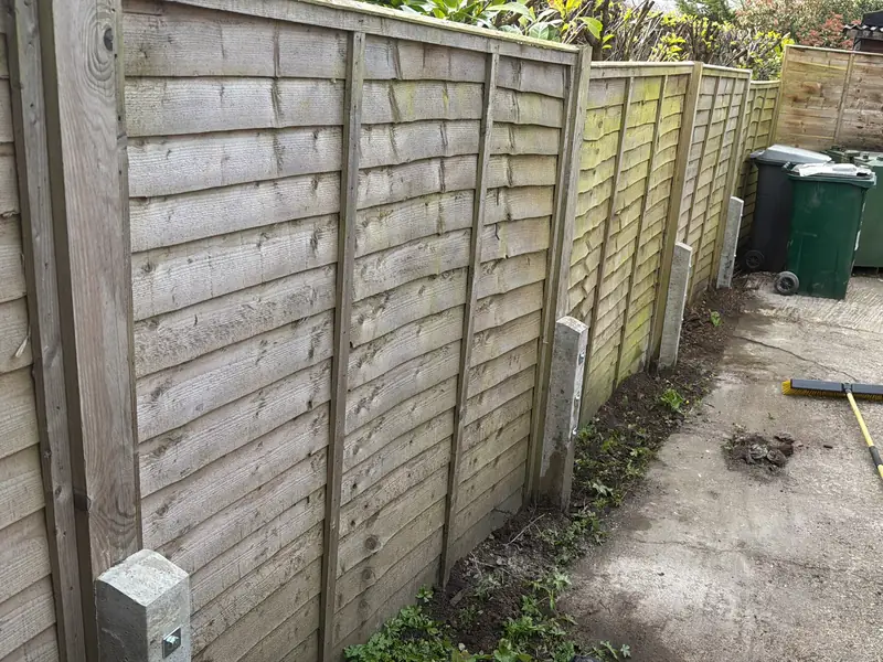 Same fence after concrete repair spurs were bolted to the posts